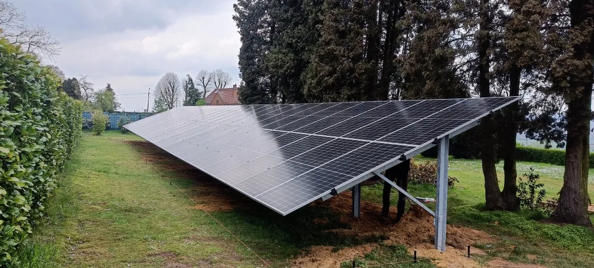 Panneaux photovoltaïques sur structure au sol le long d’une haie