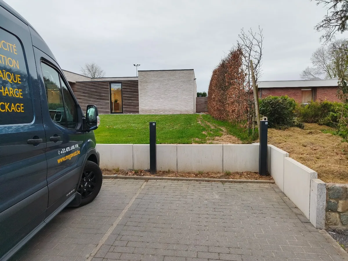 Camionnette Megawatt devant une borne de recharge posée dans une allée